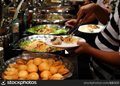 buffet food, customer scooping the food in luxury restaurant