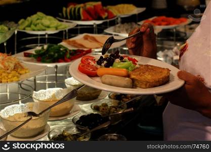 buffet food, customer scooping the food in luxury restaurant
