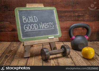 Build good habits inspirational advice or reminder - white chalk handwriting on a slate blackboard with kettlebell and dumbbell, fitness and lifestyle concept