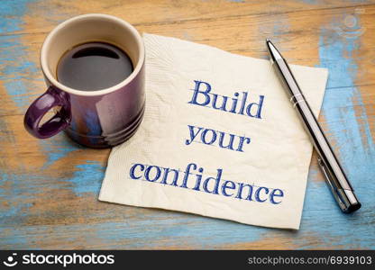 Build your confidence - handwriting on a napkin with a cup of espresso coffee