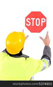 Builder affixing stop sign