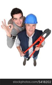 Builder and apprentice stood with bolt cutters