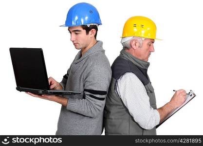Builder and apprentice with laptop and clipboard