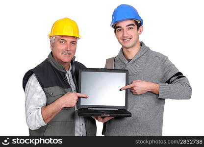 Builder and youth worker pointing at laptop