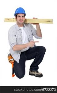 Builder carrying wood on shoulder