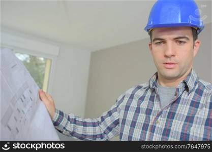 Builder checking building plans