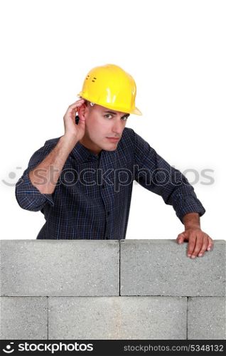Builder covering ear with hand