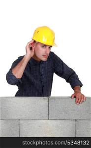 Builder covering ear with hand
