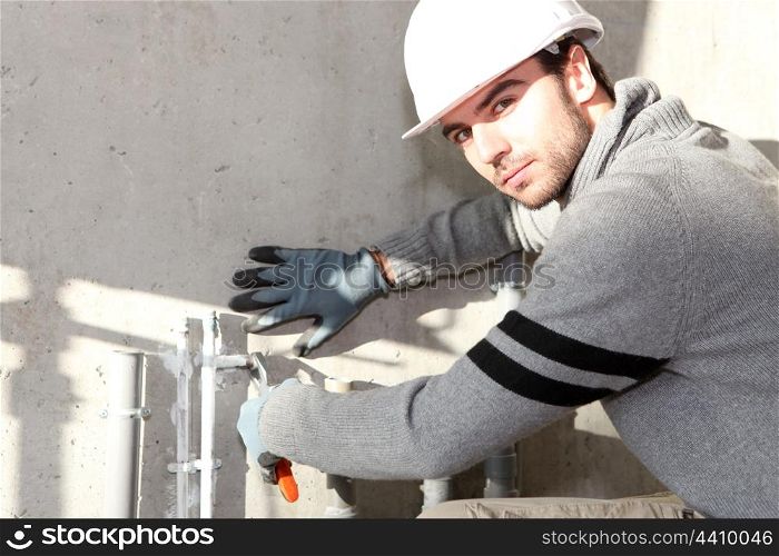 Builder cutting an outdoor pipe