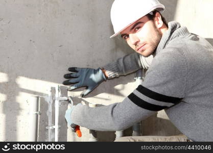 Builder cutting an outdoor pipe