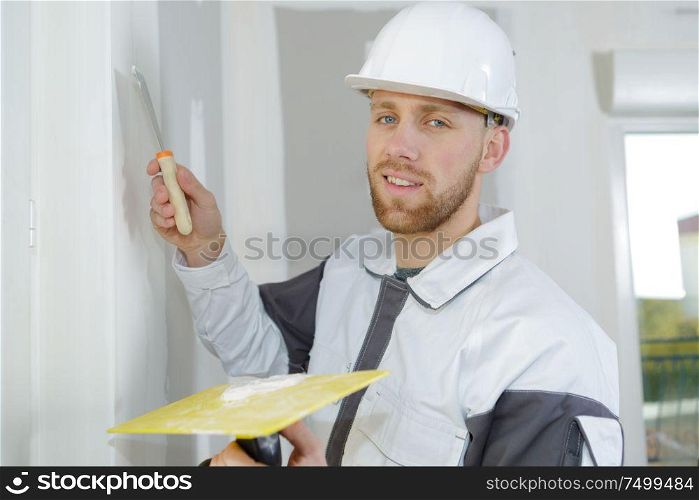builder filling the holes on the wall