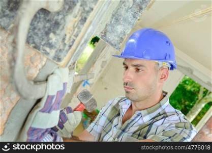 Builder fixing metal tie to wall