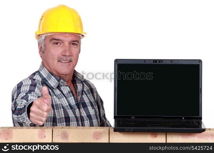 Builder giving the thumbs up to a laptop with a blank screen