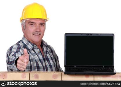 Builder giving the thumbs up to a laptop with a blank screen