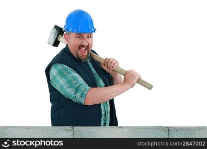 Builder hitting a wall with a sledgehammer