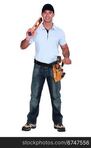 Builder holding spirit level and hammer