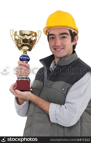 Builder holding trophy