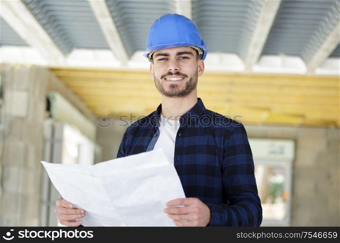 builder man in helmet with drawing project work construction designer