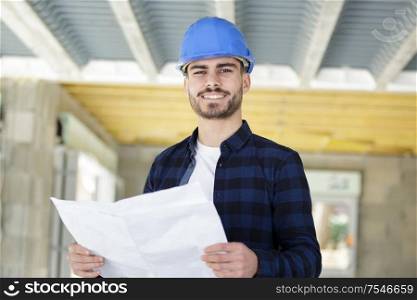 builder man in helmet with drawing project work construction designer