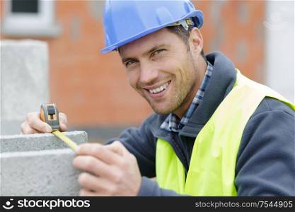 builder measuring a cement block