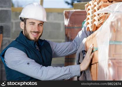 builder next to roof tiles