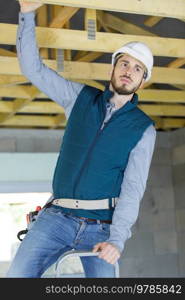 builder on the ladder gesturing