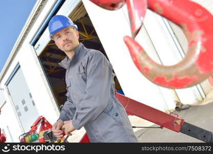 builder operating a crane hook outdoors