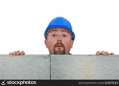 Builder peering over wall