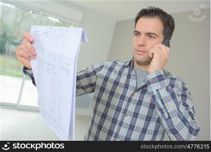 Builder phoning architect to check plans