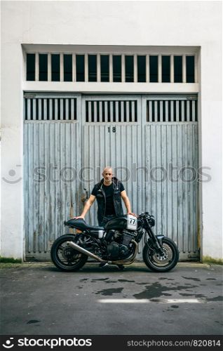 Builder posing with a custom motorcycle in front of the garage door. Builder posing with a motorcycle