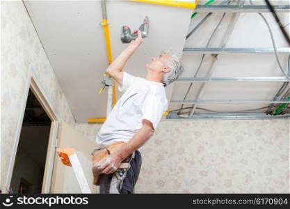 Builder putting up a suspended ceiling