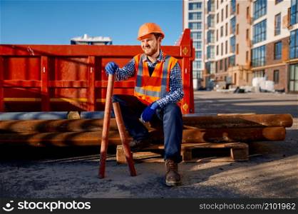 Builder rest sitting on pipe pile. Laying groundwater system for new residential buildings. Construction worker rest sitting on pipe pile