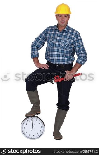 Builder resting foot on clock