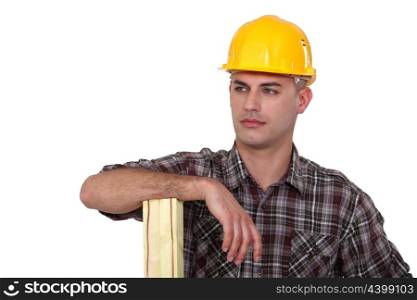 Builder stood with plank of wood