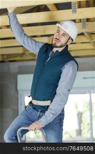 builder supervising wooden roof construction