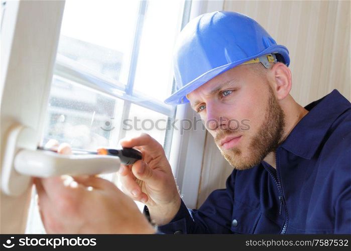 builder tightening a screw with a screwdriver