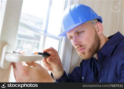 builder tightening a screw with a screwdriver