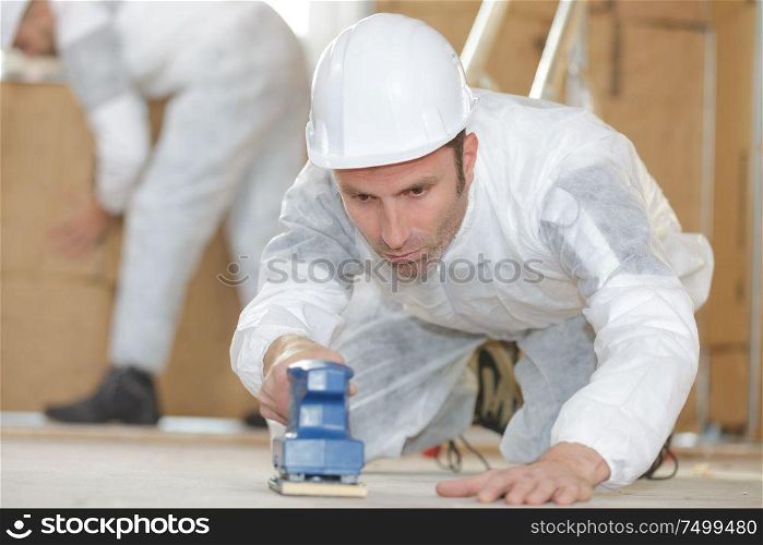 builder using sander on floor