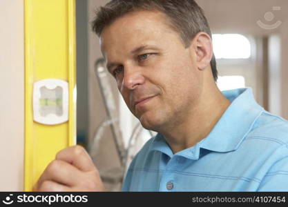 Builder Using Spirit Level On Wall