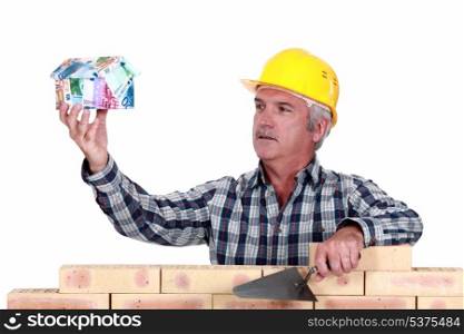 Builder with a house made of money