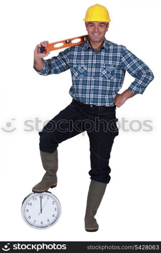 Builder with a spirit level and a clock