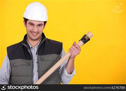 Builder with a wooden handled tool