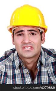 Builder with pained expression on face