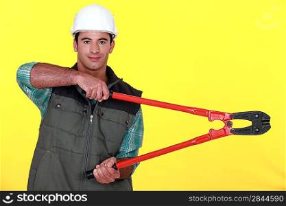 Builder with shears on yellow background