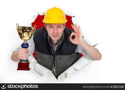 Builder with trophy making OK sign