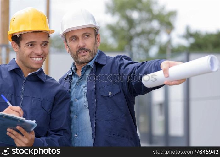 builders in helmets pointing outdoors