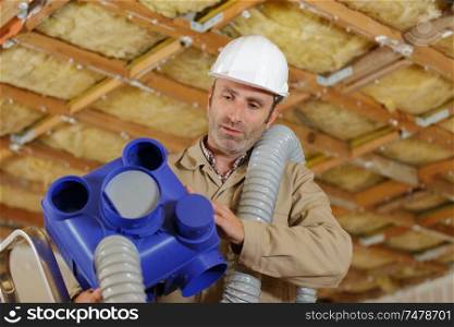 builders working on ventilation pipes