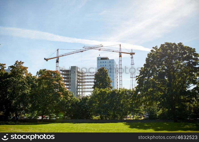 building, architecture, industry and engineering concept - crane at construction site building living house