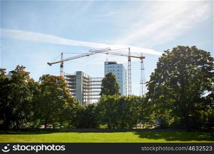 building, architecture, industry and engineering concept - crane at construction site building living house