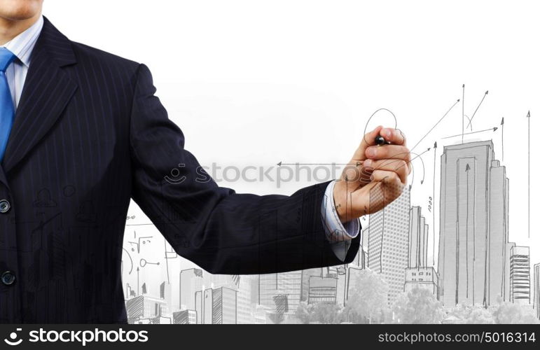 Building business. Close up of businessman drawing business sketches with marker